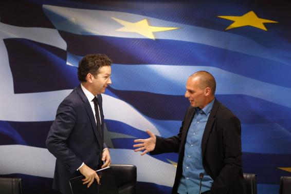 Jeroen Dijsselbloem, (L) head of the euro zone finance ministers' group, and Greek Finance Minister Yanis Varoufakis shake hands after their common press conference at the ministry in Athens January 30, 2015.  REUTERS-Kostas Tsironis