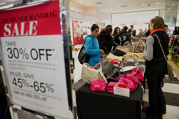 Shoppers browse handbags on sale at a Bloomingdale's store in the Westfield San Francisco Centre in San Francisco, California, U.S., on Friday, Nov. 23, 2012. To get shoppers to spend more than last year, retailers have continued to turn Black Friday, originally a one-day event after Thanksgiving, into a week's worth of deals and discounts. Photographer: David Paul Morris/Bloomberg