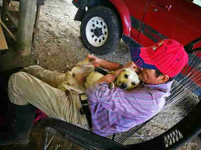 Man hugging dog to his chest
