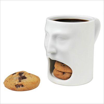 A mug that holds coffee and cookies