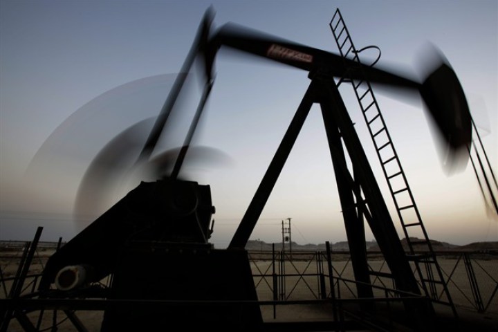  In this Oct. 14, 2014 file photo, an oil pump works at sunset in the desert oil fields of Sakhir, Bahrain. 