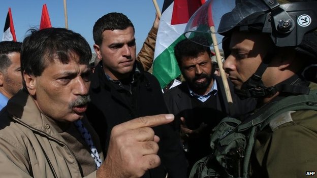 Ziad Abu Ein argues with Israeli troops at a protest in the West Bank (10 December 2014)