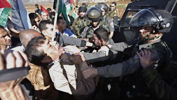 An Israeli border guard appears to grab Ziad Abu Ein at a protest near the West Bank village of Turmusaya, shortly before the Palestinian minister's death (10 December 2014)
