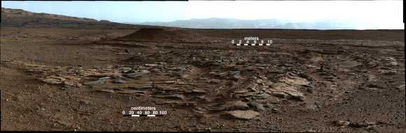 This image looks to the west of the Kimberley waypoint on the Curiosity's route to the base of Mount Sharp. The mountain lies to the left of the scene. The image shows sets of sandstone beds all inclined to the south (left) indicating progressive build-out of sediment toward Mount Sharp. These inclined beds are overlain in the background by horizontally bedded fine-grained sandstones that likely represent river deposits. The camera recorded the component frames of this mosaic on April 4, 2014, during the 590th Martian day, or sol, of Curiosity's work on Mars. The color has been approximately white-balanced to resemble how the scene would appear under daytime lighting conditions on Earth. Image credit: NASA / JPL-Caltech / MSSS.