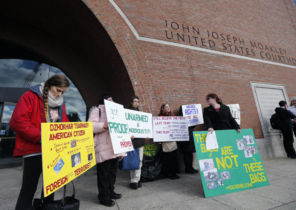 Protesters hold up signs outside federal court in Boston, on Thursday, Dec. 18, 2014, where the final hearing for Boston Marathon bombing suspect...