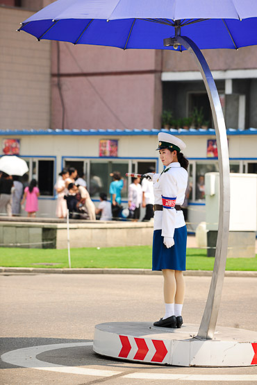 Dolled up in blue and white uniforms, pretty girls work the middle of intersections.