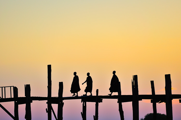 monks walking over mandalay bamboo brigde