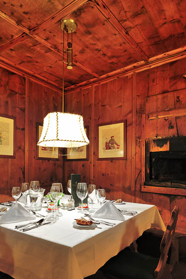 table set for dinner in the cosy and historical stube of the Jagdschloss Hotel Jagdschloss Hotel of Count Stolberg - Kühtai, Austria
