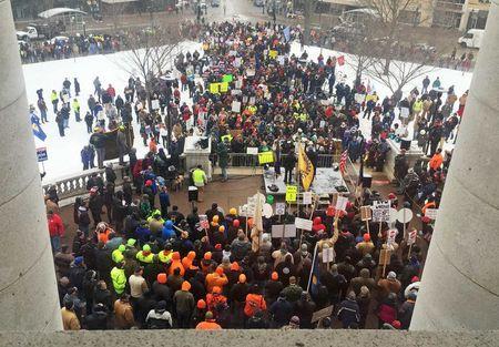 Workers gather outside the State Capitol building in Madison