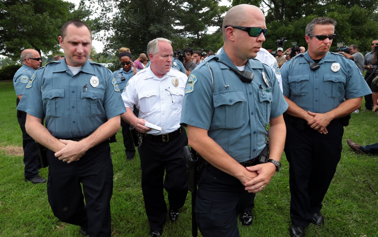 Ferguson Police Chief Tom Jackson is surrounded by his officers as he leaves a news conference in August. (AP/St. Louis Post-Dispatch, Robert Cohen)