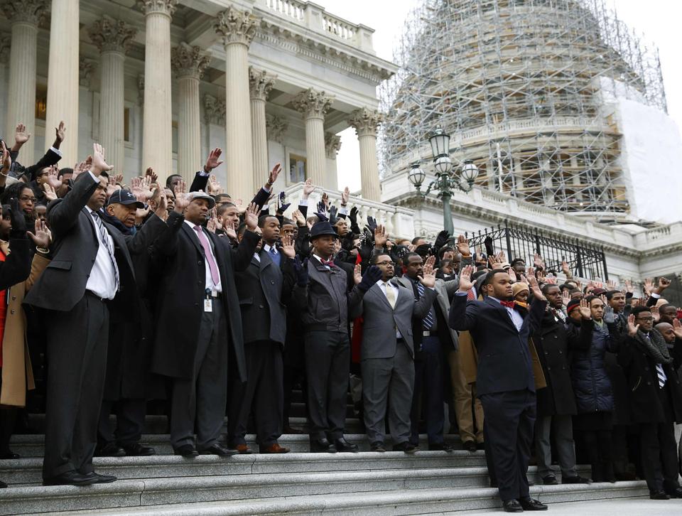 African-American Congressional staffers stage walk out with Hands Up Don&#39;t Shoot pose on the steps of the House of Representatives in Washington...