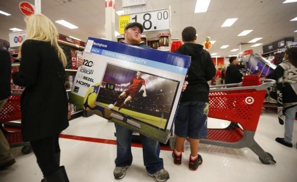 A Thanksgiving Day holiday shopper carries a discounted television to the checkout at the Target retail store in Chicago, Illinois, November 28, 2013. REUTERS/Jeff Haynes