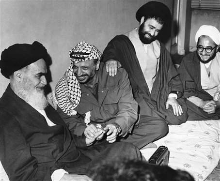 File - Ayatollah Ruholla Khomeini, left, smiles at something Yasser Arafat is saying February 18, 1979 in Tehran, Iran. The Ayatollah's son has his hand on Arafat's shoulder.