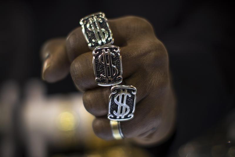 A man wears dollar sign rings in a jewellery shop in Manhattan in New York City