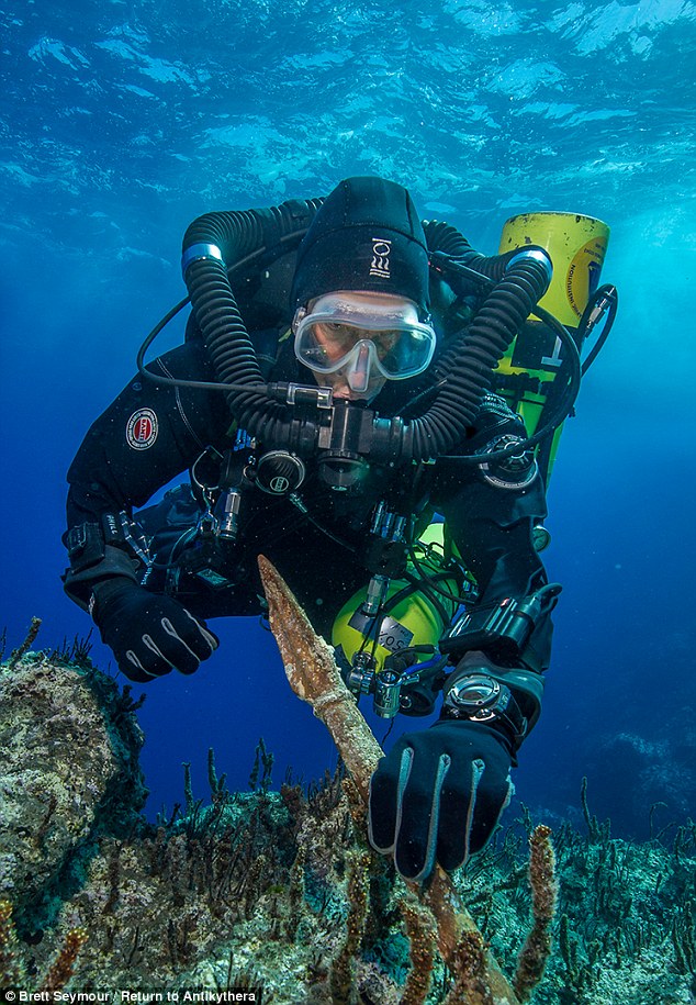 Return to Antikythera project chief diver Philip Short inspects the bronze spear recovered from the Antikythera Shipwreck
