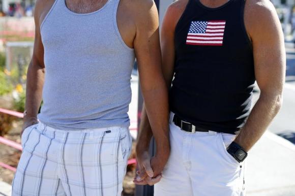 A gay couple holds hands during a rally in support of the United States Supreme Court decision on marriage rights in San Diego, California June 26, 2013. REUTERS/Mike Blake